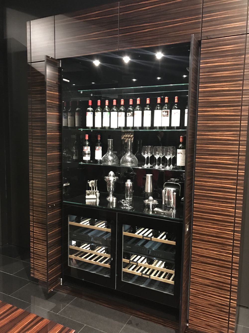 The central section of this unit is a bar, complete with two wine coolers at the bottom and a set of shelves