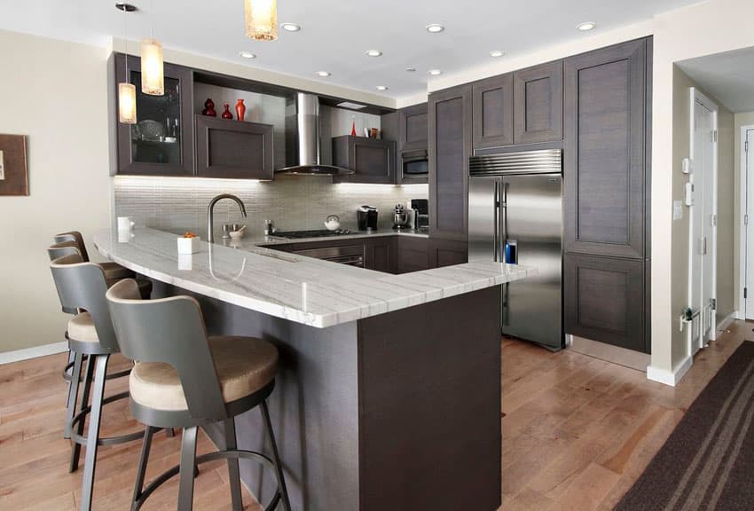 Contemporary kitchen with peninsula dark cabinets and mini pendant lights