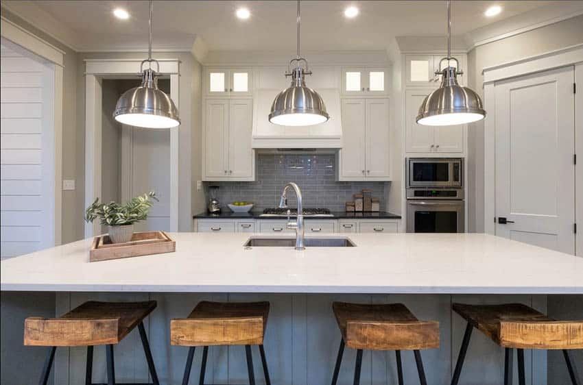 Contemporary kitchen with white quartz countertops, glass backsplash and chrome pendant lights