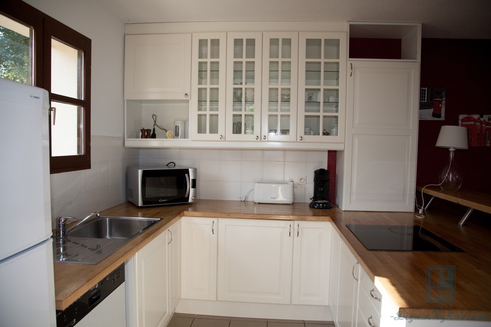 Белая кухня с мраморной столешницей и фартуком в интерьере