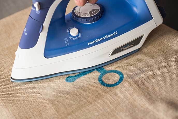ironing a decal onto synthetic fabric