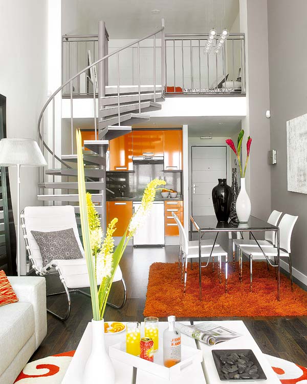 Интерьер квартиры с винтовой лестницей на второй уровень над кухней