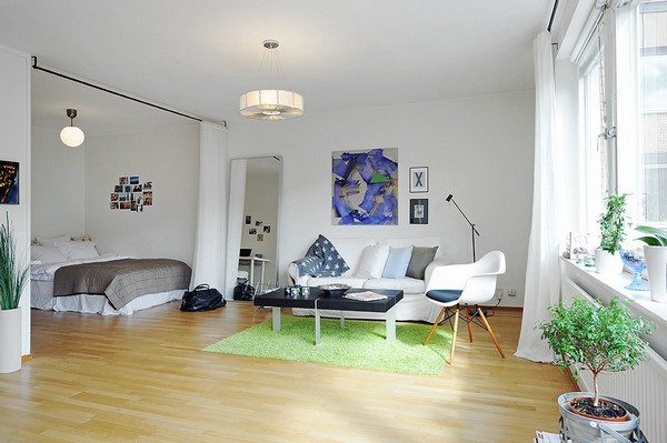 Интерьер квартиры с отделением пространства с кроватью белым занавесом от потолка до пола