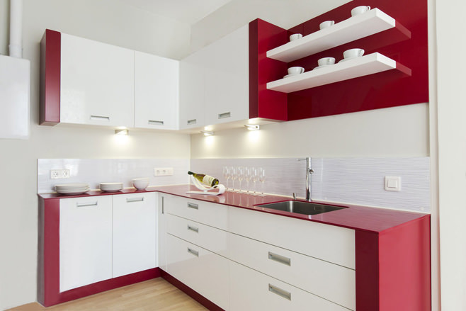 Стильный интерьер белой кухни на фоне красной стены и бордовых занавесей