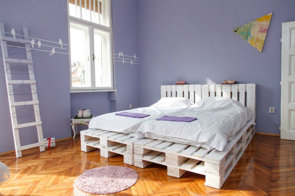Интерьер спальной с кроватью из паллет окрашенных в белый цвет