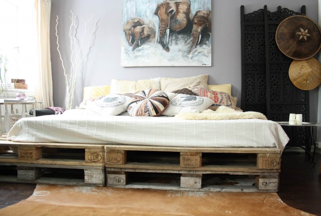 Самодельная кровать из строительных европоддонов в интерьере спальной