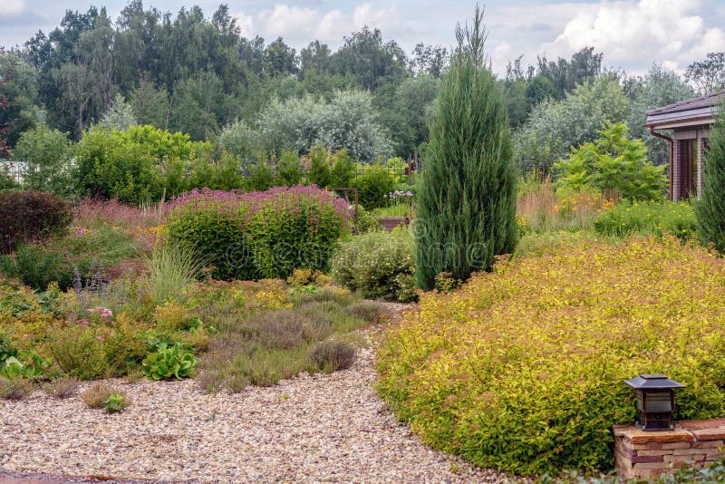 Amazing garden with perennials close to dacha  in russian prosperous village named `belgian village`. Amazing garden with perennials close to dacha mansion  in stock photography