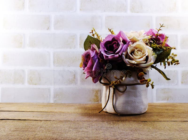 Artificial pink roses flowers in vase on wooden and space wallpaper. Artificial rose flowers in vase on wooden and space wallpaper royalty free stock image