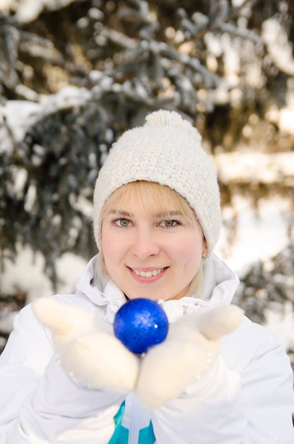 Beautiful attractive blonde girl in sportswear holding a ball to decorate a Christmas tree. vertical view stock images