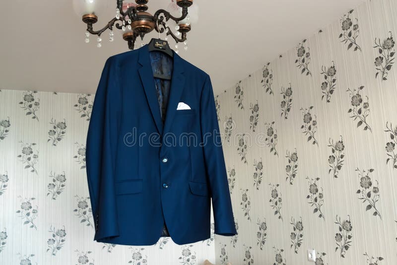 Beautiful blue groom`s jacket hanging on the chandelier.  royalty free stock photos