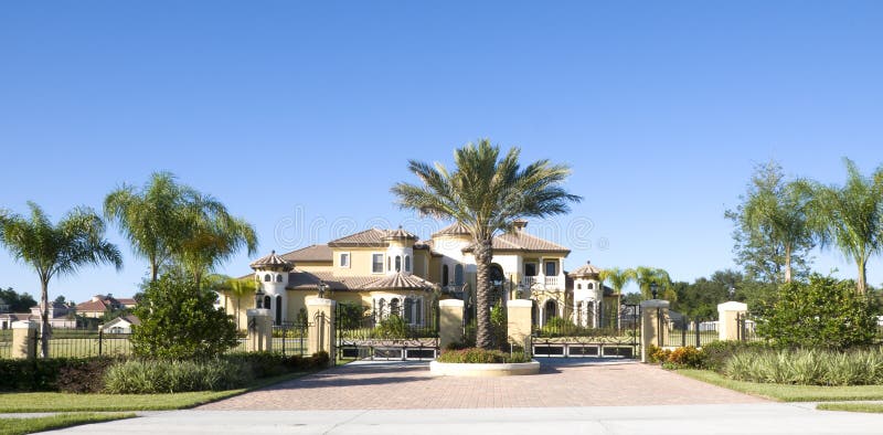 Beautiful Mansion. With palm tree gated entrance and blue sky stock photos Beautiful Mansion. With palm tree gated entrance and blue sky stock photos