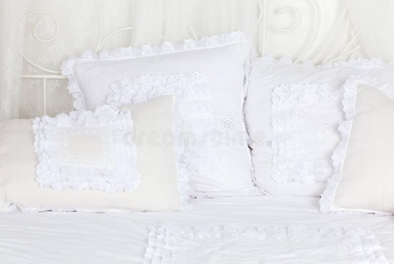 Beautiful and soft white laced pillows on bed. stock images