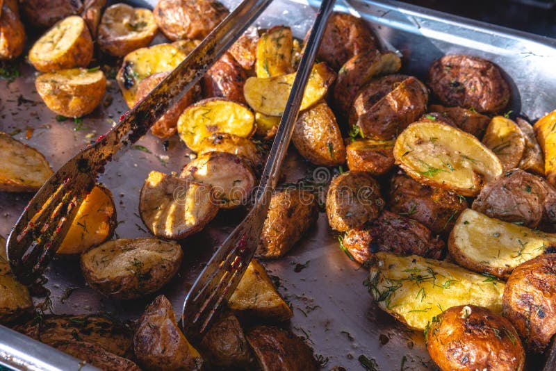 Beautiful and tasty grilled fried potatoes with dill food court, distribution of food in metal dishes, festival food, dining room stock image