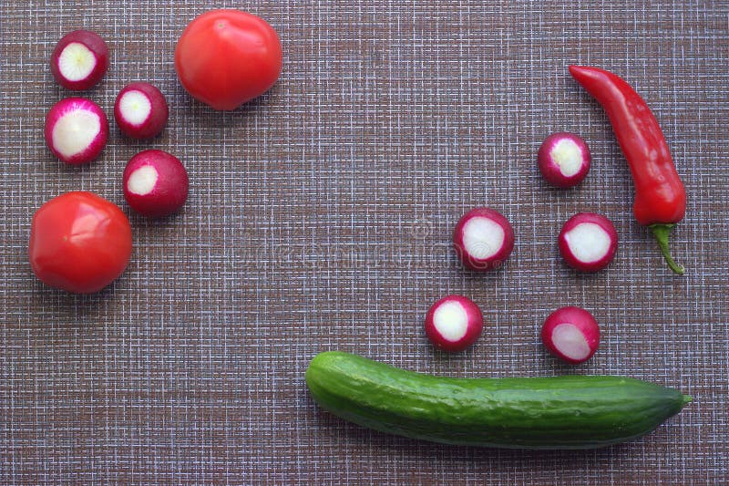 Beautifully laid out in the corners of a textile napkin spring and summer vegetables: tomatoes, cucumbers, radishes and zucchini stock photography