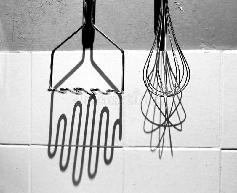 Black and white photograph of potato masher and whisky hanging up royalty free stock image