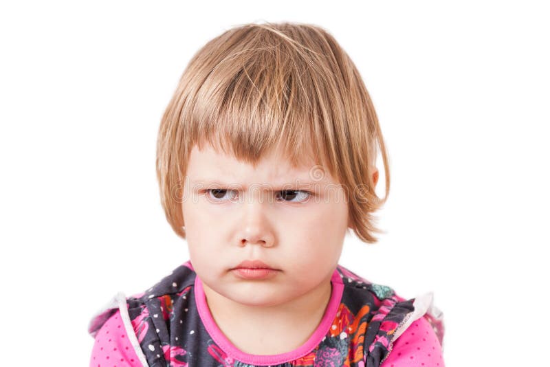 Blond baby girl angry frowns, studio portrait stock image