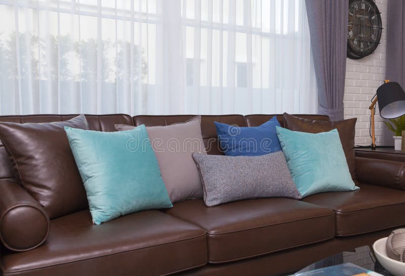 Blue and gray pillows on leather sofa in modern living room stock photos