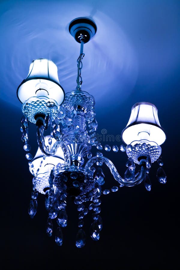 Chandelier. A crystal chandelier shining blue light royalty free stock photography