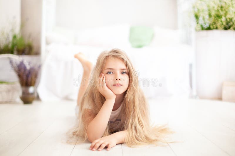Childhood concept. The child plays in the children`s room. Little blonde girl in pajamas at home. time for sleep and rest. Baby gi. Rl in a cozy Scandinavian royalty free stock images