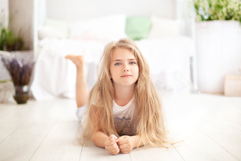 Childhood concept. The child plays in the children`s room. Little blonde girl in pajamas at home. time for sleep and rest. Baby gi. Rl in a cozy Scandinavian royalty free stock photo