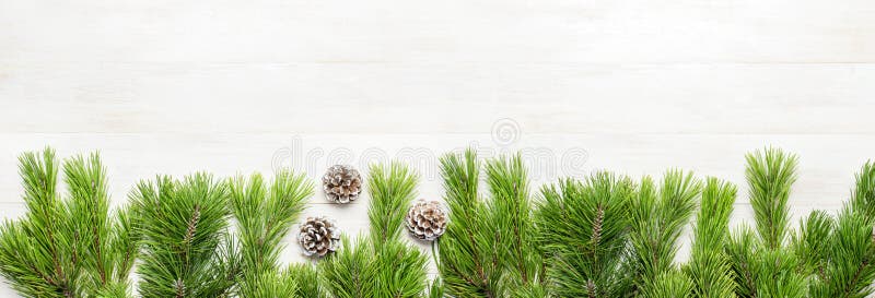 Christmas background, green pine branches, cones decorated with snow on white wooden table. Creative composition with border and c stock images Christmas background, green pine branches, cones decorated with snow on white wooden table. Creative composition with border and c stock images