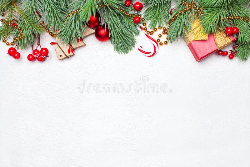 Christmas border composition with green Xmas fir branch, red holly berries and baubles on white texture stucco plaster background royalty free stock photos Christmas border composition with green Xmas fir branch, red holly berries and baubles on white texture stucco plaster background royalty free stock photos