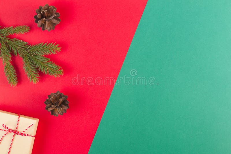 Christmas composition on red and green background. Green fir tree branch, pine cones and present box royalty free stock photos Christmas composition on red and green background. Green fir tree branch, pine cones and present box royalty free stock photos