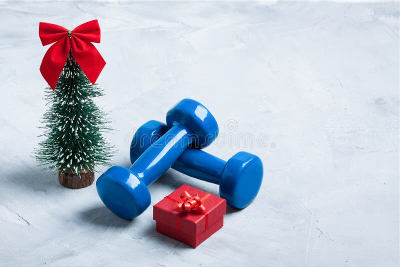 Christmas sport composition with dumbbells, red gift box, christ royalty free stock photo Christmas sport composition with dumbbells, red gift box, christ royalty free stock photo