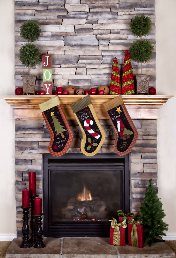 Christmas stockings hanging from fireplace. Christmas stocking hanging from a mantel or fireplace, decorated for Christmas with fire glowing stock photography