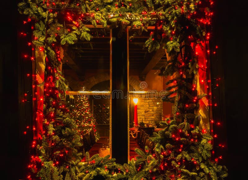 Christmas tree and fireplace seen through a wooden cabin window. Outdoor stock photography