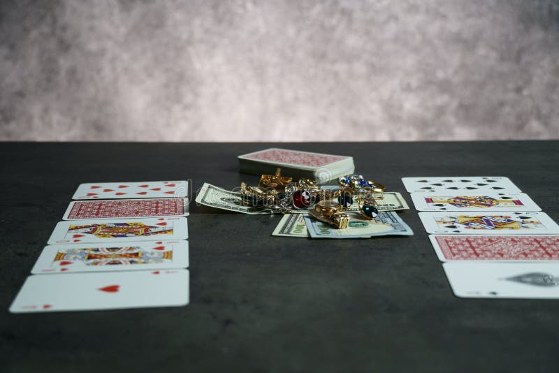 The combination of Flash Royal cards on a gray table with money and gold. Close-up. Poker game. Photo stock photos