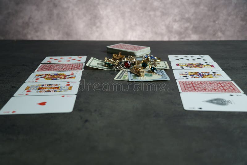 The combination of Flash Royal cards on a gray table with money and gold. Close-up. Poker game. Photo royalty free stock images