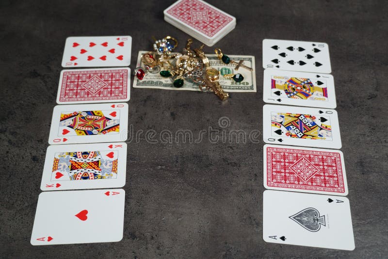 The combination of Flash Royal cards on a gray table with money and gold. Close-up. Poker game. Photo royalty free stock photography