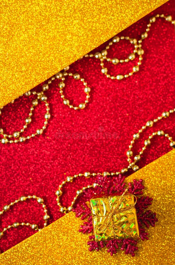 Combination of red and gold with a gift box, beautiful beads, a shiny holiday background. Christmas card, background for congratulations. A combination of red stock photography