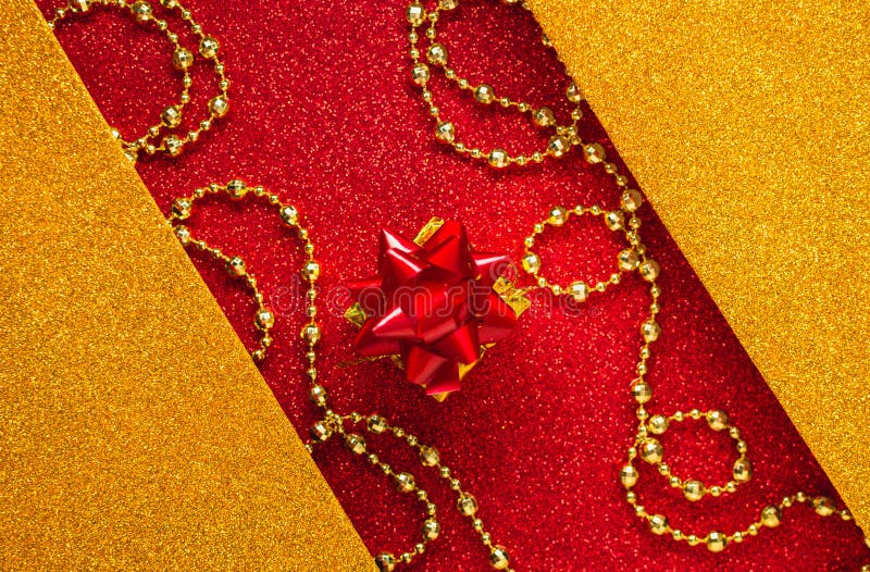 Combination of red and gold with a gift box, beautiful beads, a shiny holiday background. Christmas card, background for congratulations. A combination of red stock images