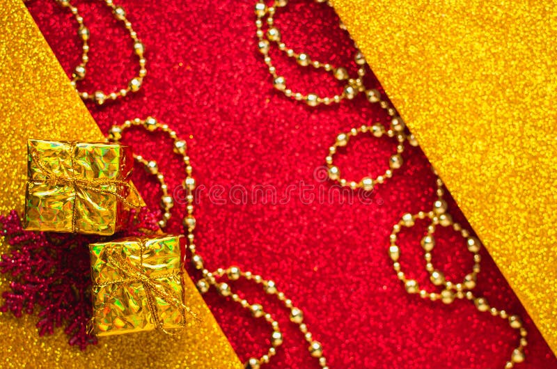 Combination of red and gold with a gift box, beautiful beads, a shiny holiday background. Christmas card, background for congratulations. A combination of red stock photos