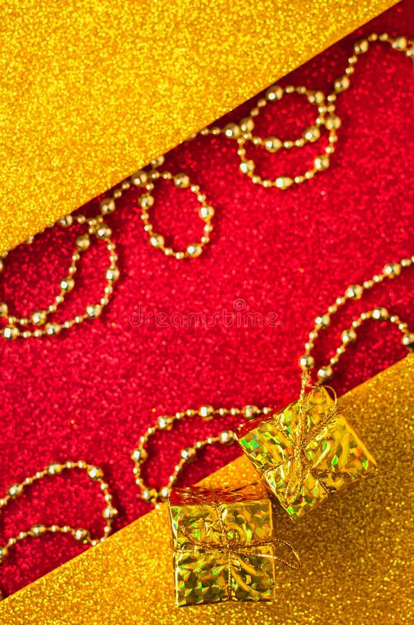 Combination of red and gold with a gift box, beautiful beads, a shiny holiday background. Christmas card, background for congratulations. A combination of red royalty free stock images