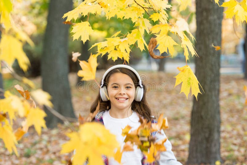 Crispy autumn air. Happy small child smile listening to music on autumn day. Little girl play on fresh air on autumn. Landscape. Smell the crisp air and feel stock image