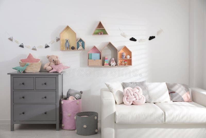 Children`s room with house shaped shelves, sofa and chest of drawers. Interior design. Cute children`s room with house shaped shelves, sofa and chest of drawers royalty free stock photos