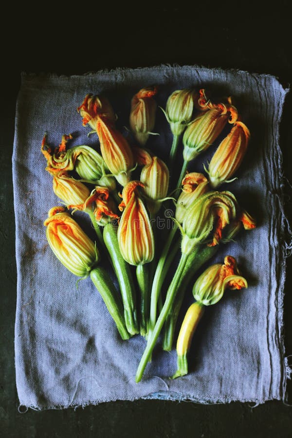 Zucchini and squash blossoms arranged beautifully on a grey napkin royalty free stock photography