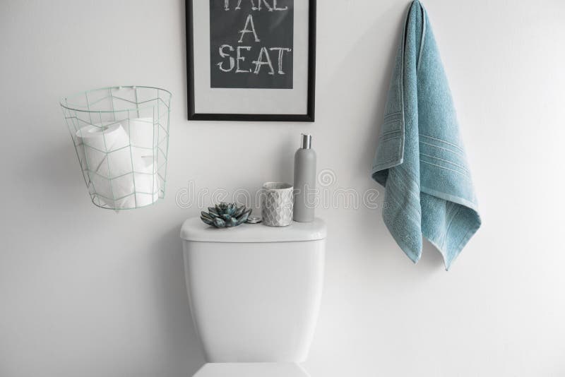 Decor elements, necessities and toilet bowl near white wall. Bathroom. Interior stock image