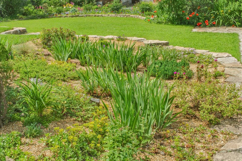 Decorative alpine slide, green lawn, flower garden royalty free stock image