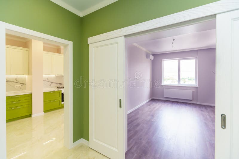 Empty hallway with green walls and marble floor in a new apartment with a fresh renovation. Doors lead from the hall to different rooms stock image