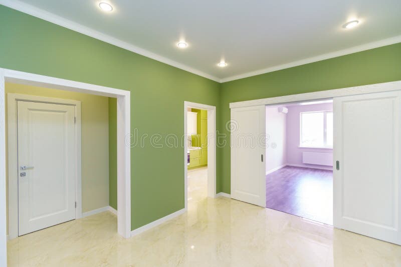 Empty hallway with green walls and marble floor in a new apartment with a fresh renovation. Doors lead from the hall to different rooms stock photography