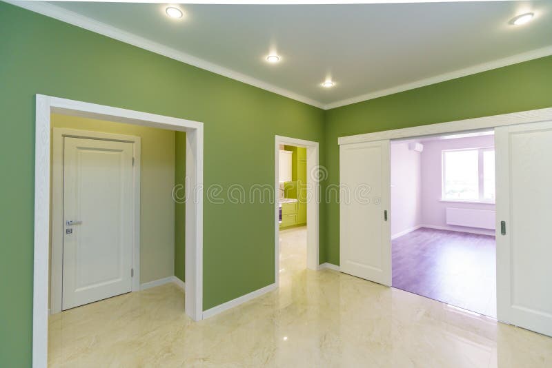 Empty hallway with green walls and marble floor in a new apartment with a fresh renovation. Doors lead from the hall to different rooms stock photo