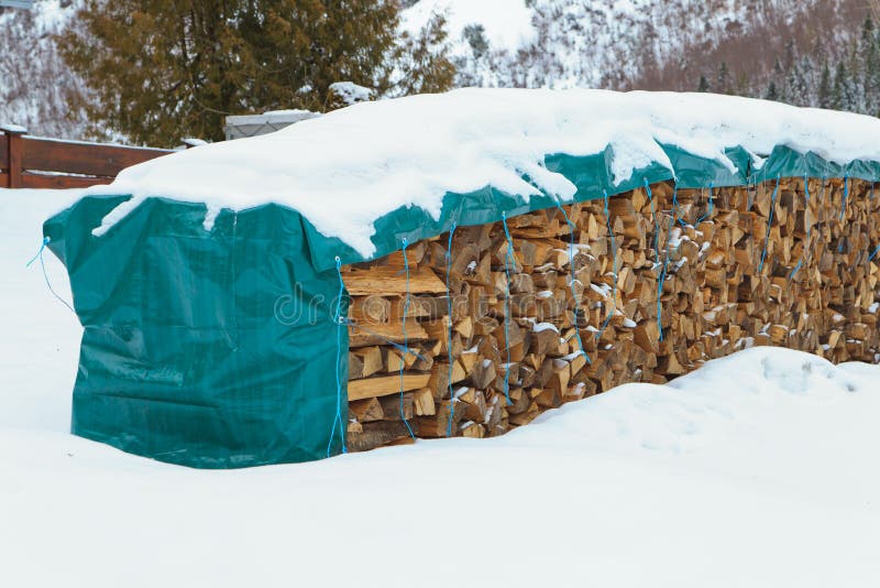 Firewood in snow. Covered by foil stock photos