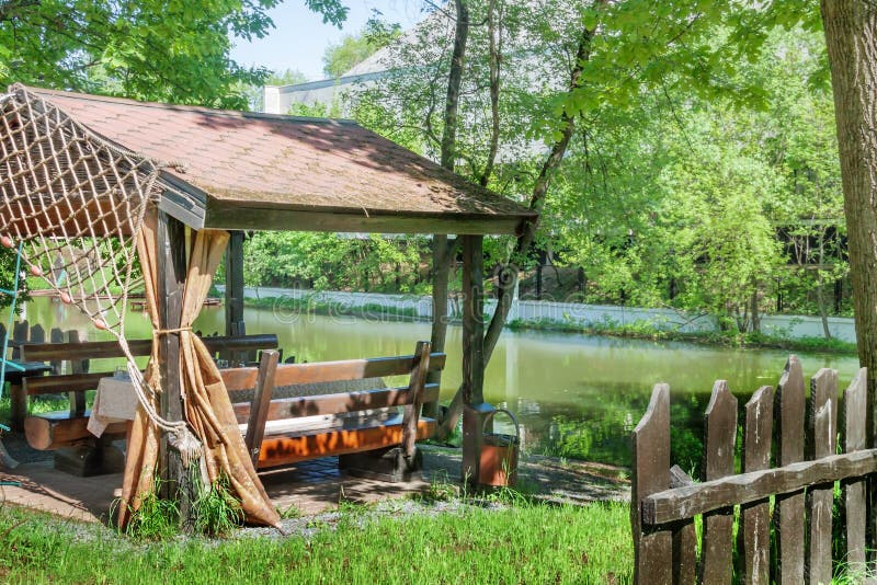 Fishing gazebo in green garden setting front or back yard by the river warm spring or summer sunny day. Fishing gazebo in garden setting front or back yard on royalty free stock photography