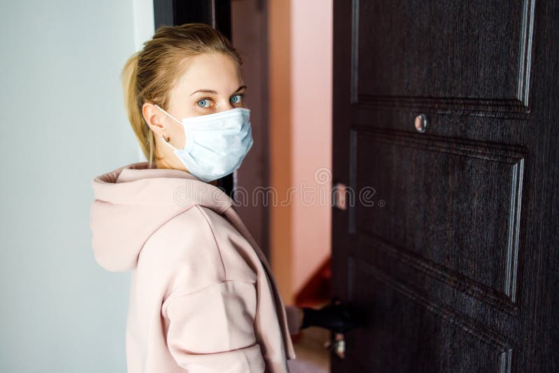 Girl in the respirator opens the front door to go outside. The girl in the respirator opens the front door to go outside royalty free stock images