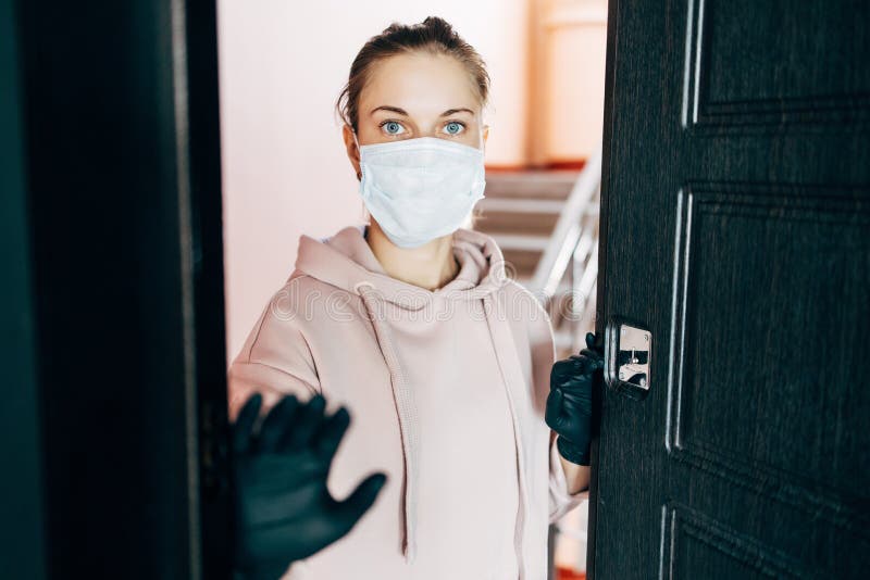 Girl in the respirator opens the front door to go outside. The girl in the respirator opens the front door to go outside stock images