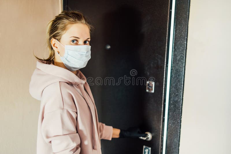 Girl in the respirator opens the front door to go outside. The girl in the respirator opens the front door to go outside royalty free stock images